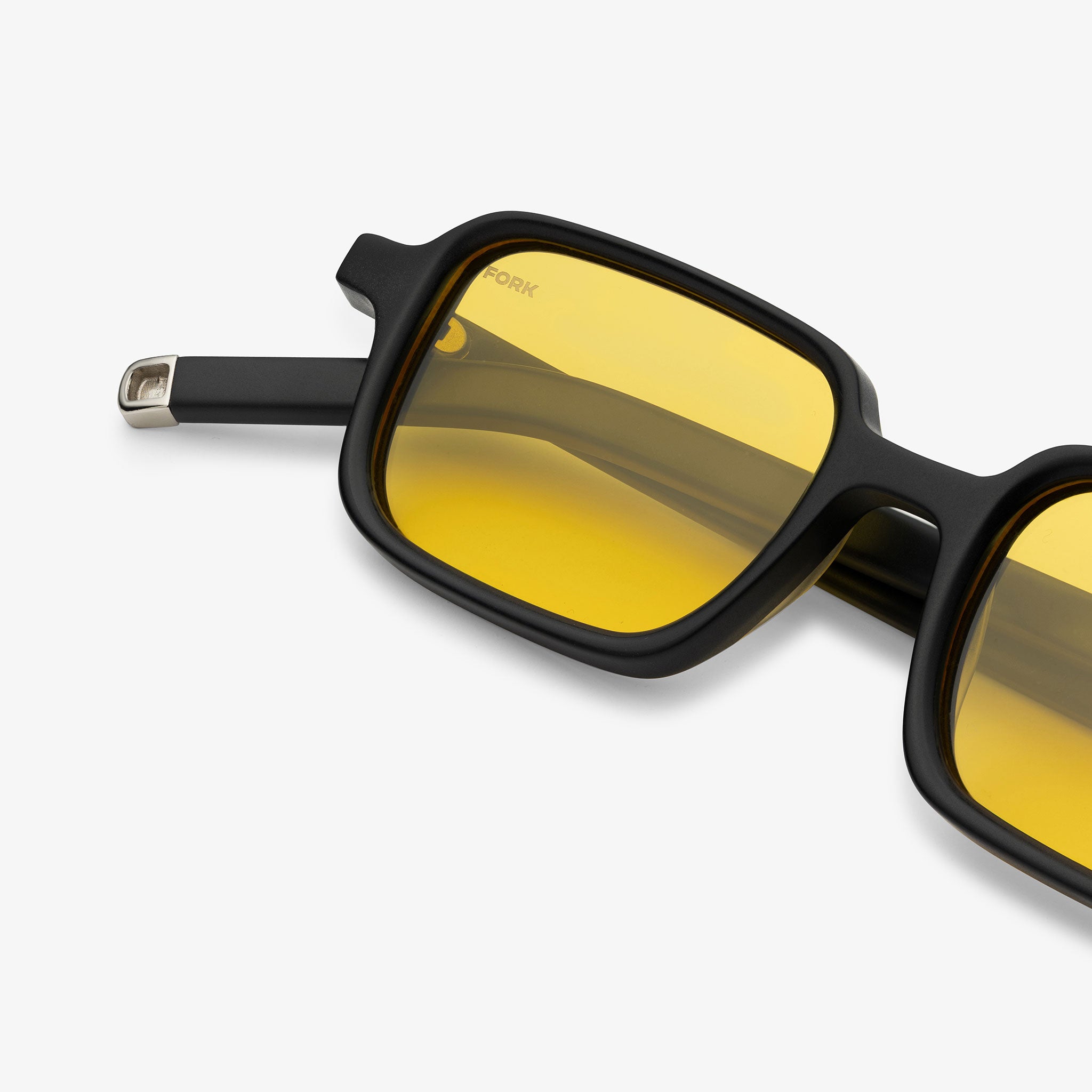 Black sunglasses with yellow lenses on a white background