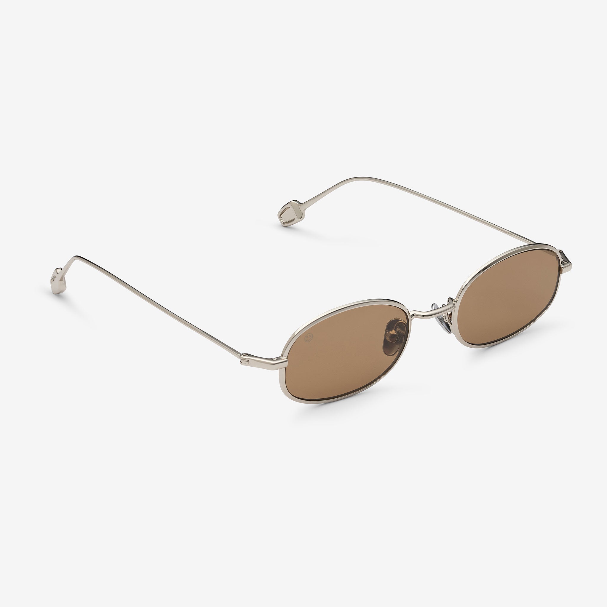 Sunglasses with thin metal frame and brown lenses on a white background