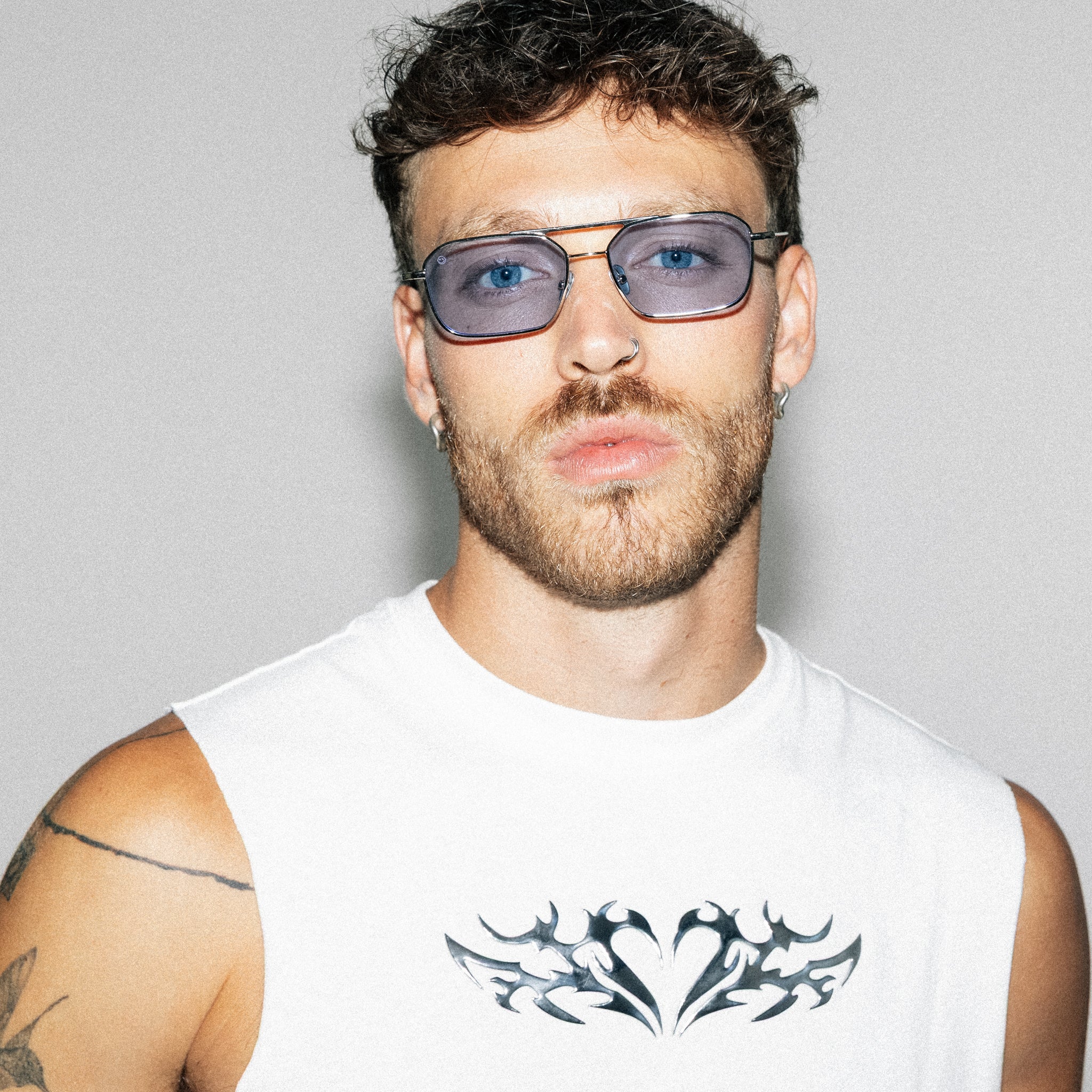 Person wearing sunglasses with a plain background