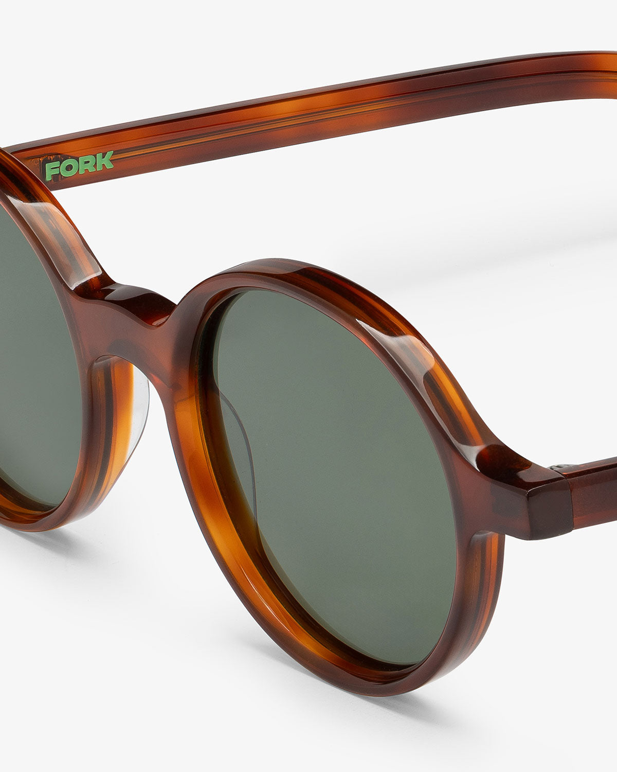 Brown sunglasses with green lenses on a white background