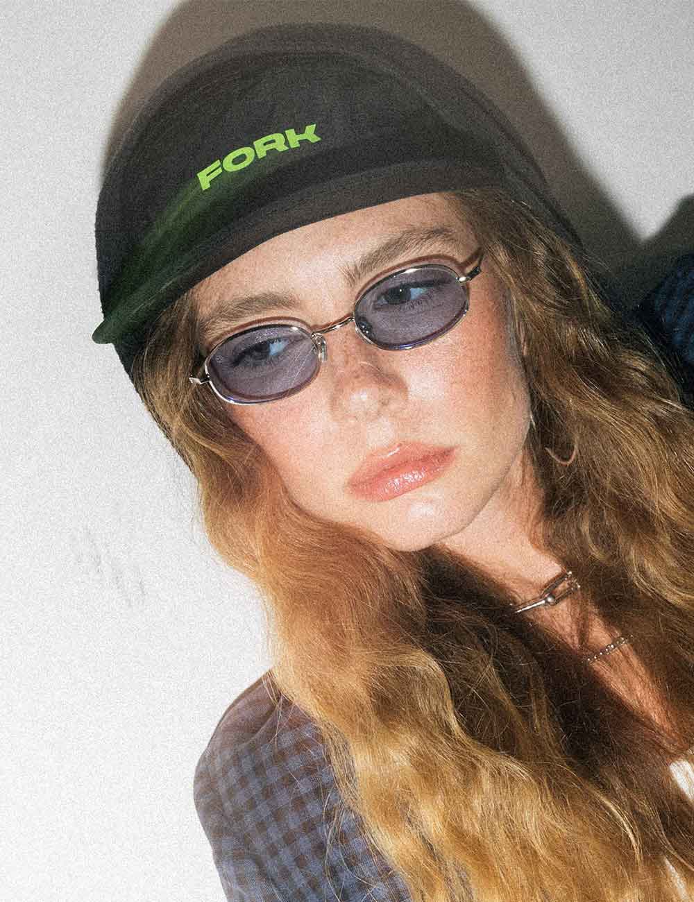 model wearing a black cap with 'FORK Eyewear' logo and sunglasses against a plain background