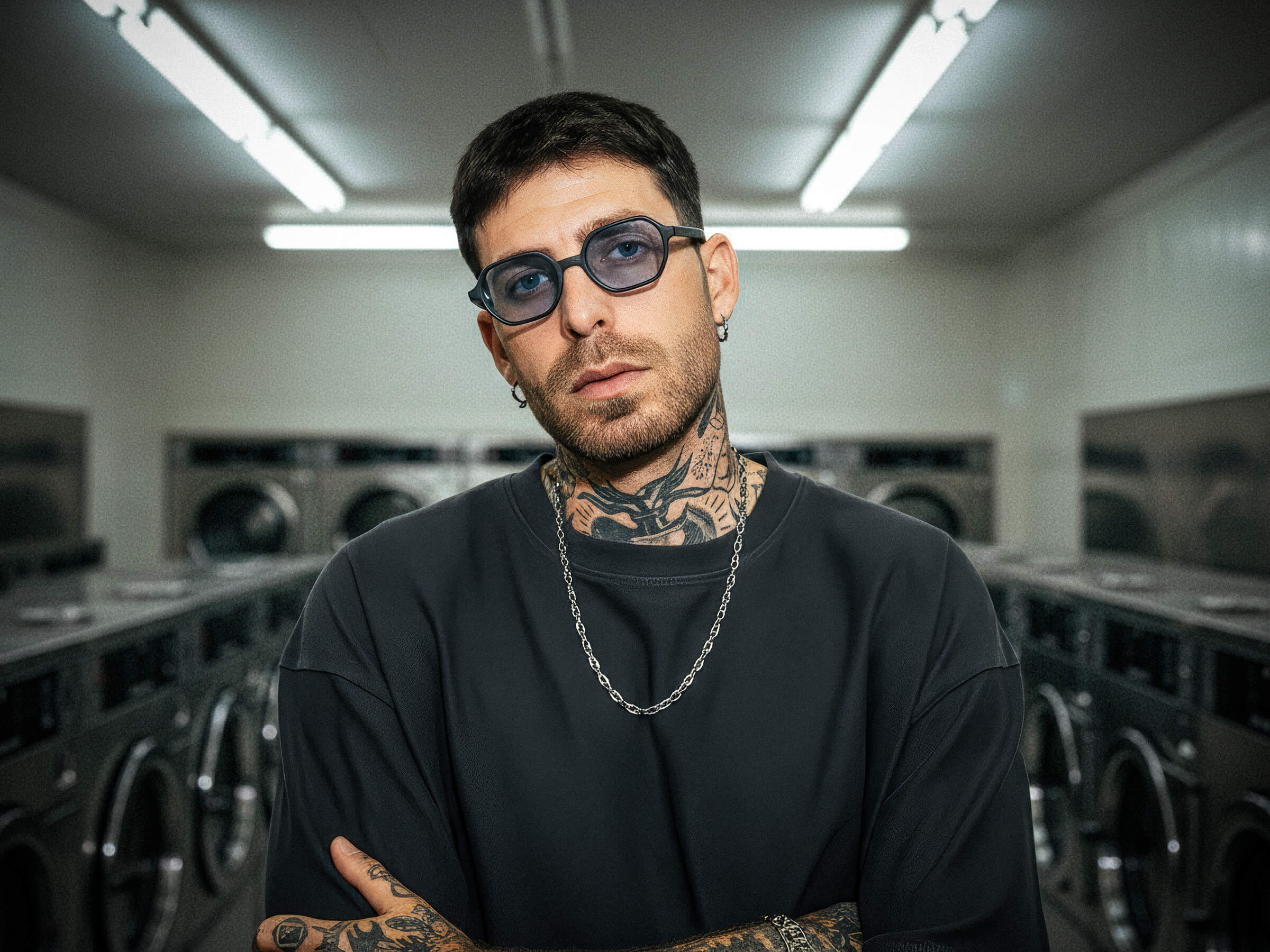 Man wearing sunglasses and a gray t-shirt in an industrial setting