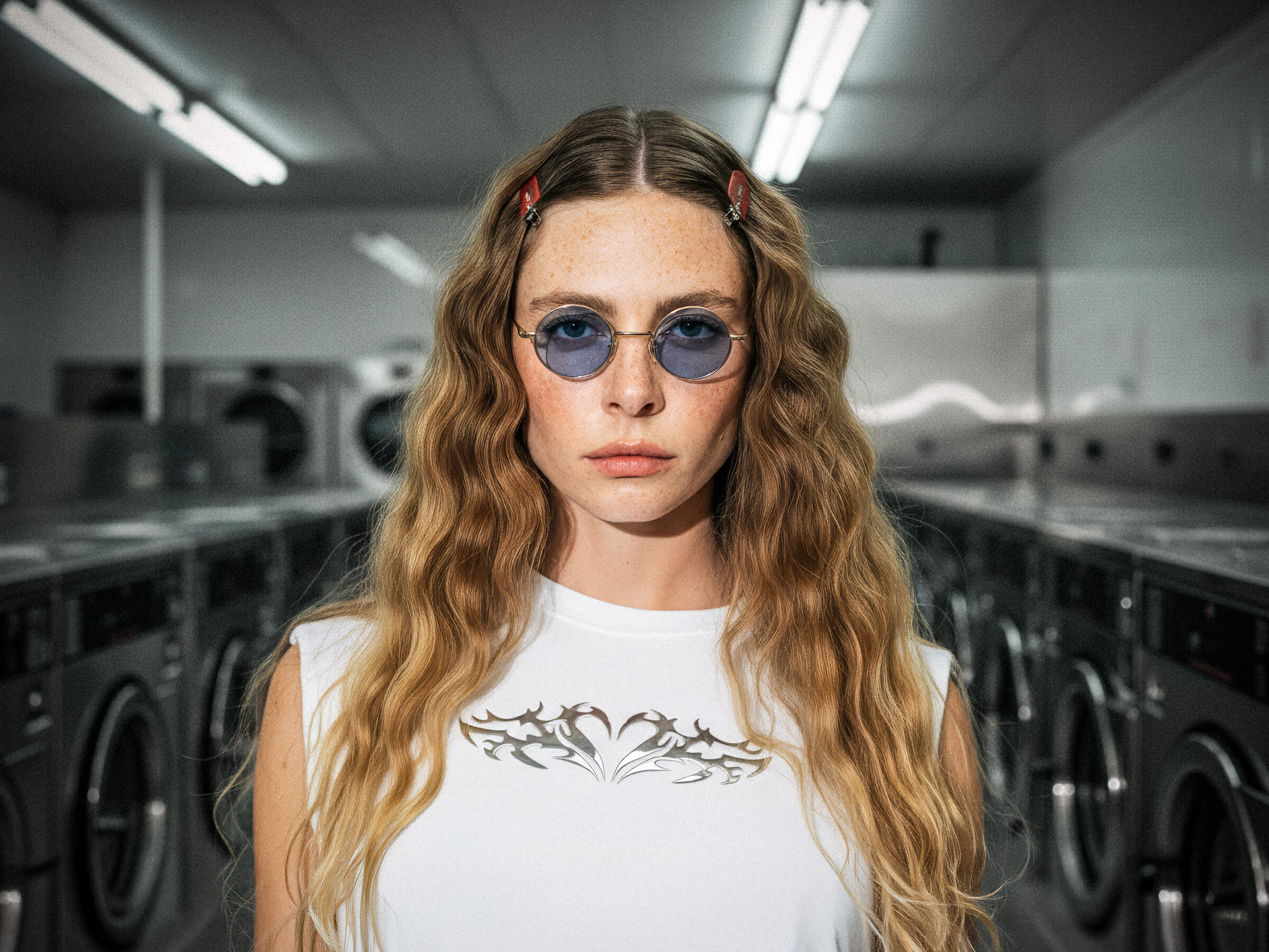 Woman wearing sunglasses in a laundromat